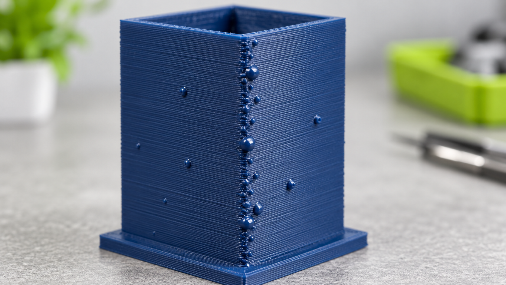 Blaues 3D-Druckteil mit deutlich sichtbaren Blobs und Pickeln auf der Außenwand